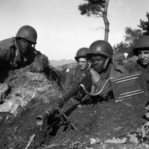 Sergeant First Class Major Cleveland points out North Korean position to his machine gun crew, 1950.